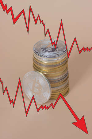 Bitcoins with red arrow. Fall of bitcoin concept.の写真素材