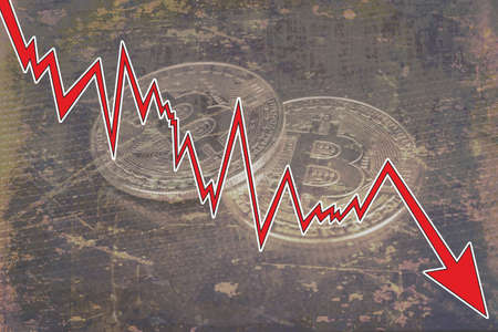 Bitcoins with red arrow. Fall of bitcoin concept.の写真素材