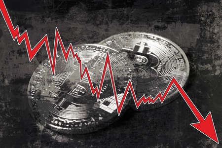 Bitcoins with red arrow. Fall of bitcoin concept.