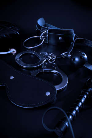 Closeup shot of erotic toys for bdsm over dark background