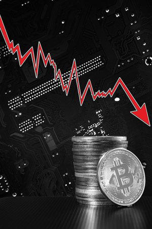 One silver bitcoin and stack of bitcoins over blurred motherboard.の写真素材