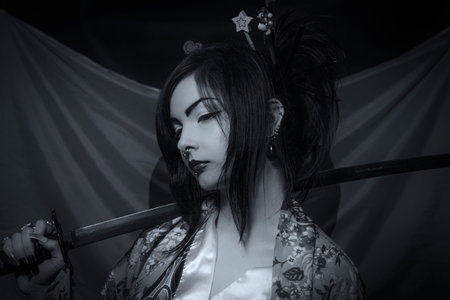 Beautiful asian young woman with katana over japanese flagの写真素材