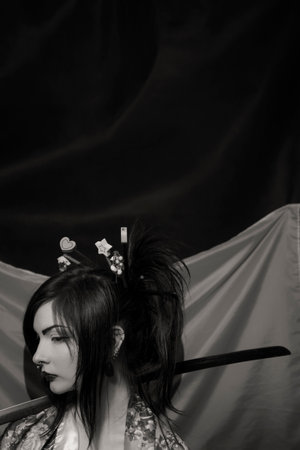 Beautiful asian young woman with katana over japanese flagの写真素材