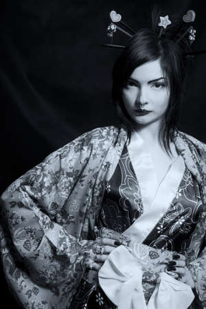 Beautiful young asian woman in kimono over dark backgroundの写真素材