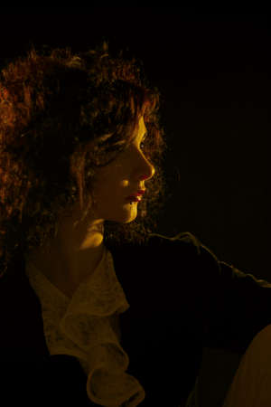 Pretty old fashioned girl posing over dark background