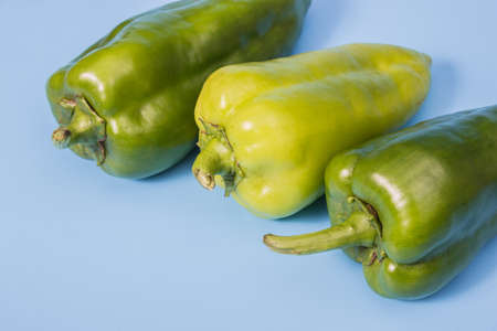 Close-up shot of three green peppers over blue backgroundの写真素材
