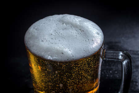 Close-up shot of mug of beer over dark background