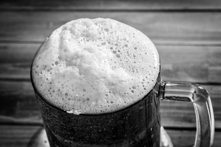 Close-up shot of mug of beer on wooden tableの写真素材