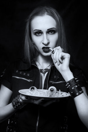 Gothic girl posing with her Halloween dinnerの写真素材