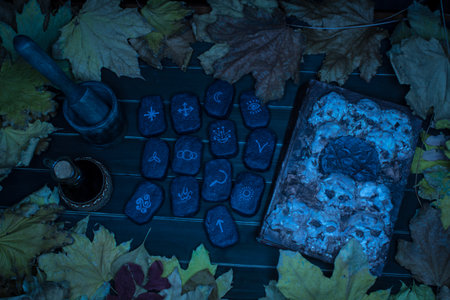 Wicca divination runes, spell book, mortar and pestle over wooden planksの写真素材