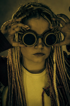 Cyberpunk girl with googles posing over grey backgroundの写真素材