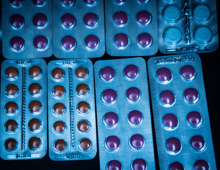 Red and orange pills in blister packs over black background
