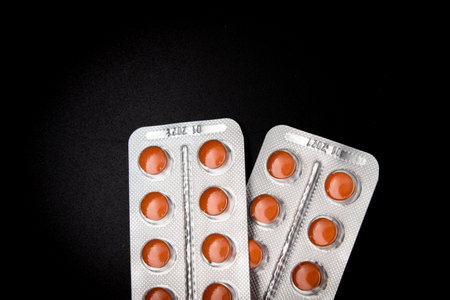 Pills in blister packs over black background