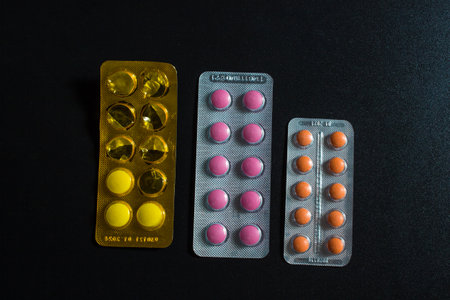 Pills in blister packs over black background