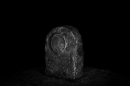 Tombstone with ethereum symbol in green grass over black backgroundの写真素材