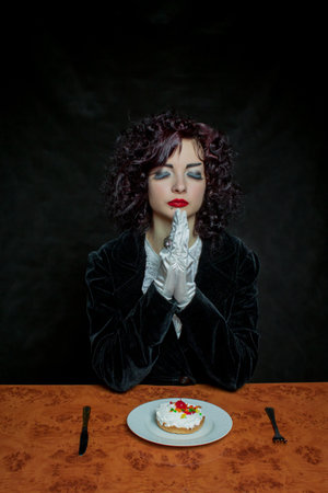 Pretty young girl with cherry fancy cake over dark backgroundの写真素材