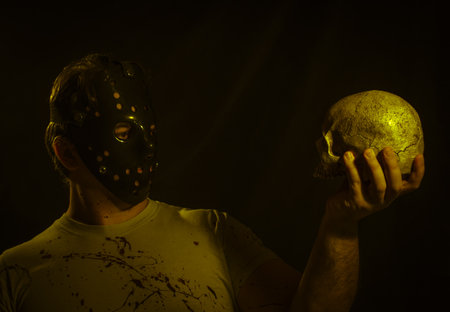 Portrait of maniac in mask over dark backgroundの写真素材