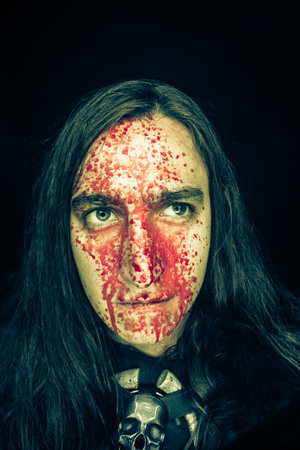 Northern warrior with blood on his face over dark background