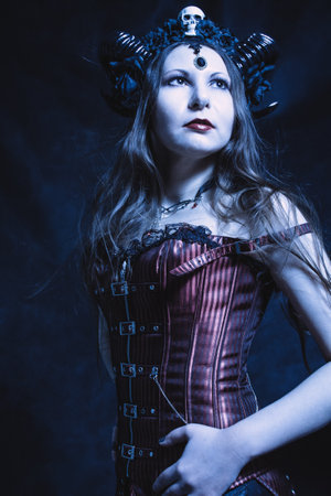 Horned pretty girl posing over dark background