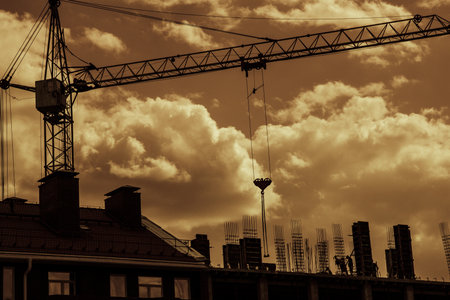 Silhouette of tower crane over skyの写真素材