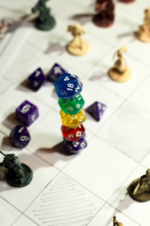 A vertical arrangement of several twenty-sided dice (D20) carefully stacked on top of each other, forming a precarious tower. The image captures a sense of tension and anticipation, evoking themes of chance, strategy, and adventure in tabletop role-playing games.の写真素材