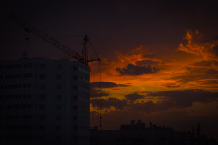 Silhouette of tower crane over sunset