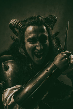A dramatic fantasy portrait of a fierce tiefling rogue wielding a dagger, captured in a dark,...