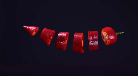 flying red pepper on black background