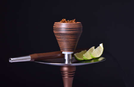 hookah bowl with tobacco on an black background with limeの写真素材