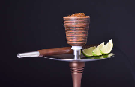 hookah bowl with tobacco on an black background with limeの写真素材