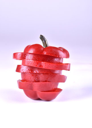 chopped red pepper with water drops on white backgroundの写真素材