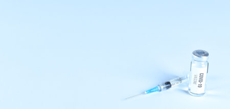 Vaccine against covid-19 and a syringe with a vaccine. Space for textの写真素材