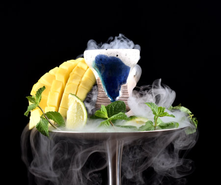 hookah bowl with tobacco on an black background with mango, lime, mintの写真素材