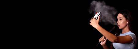 girl smokes a hookah and takes a selfie on a mobile phone. Fashion. Space for text. Bannerの写真素材