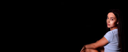 young girl with a pleasant appearance on a black background. place for text. Bannerの写真素材