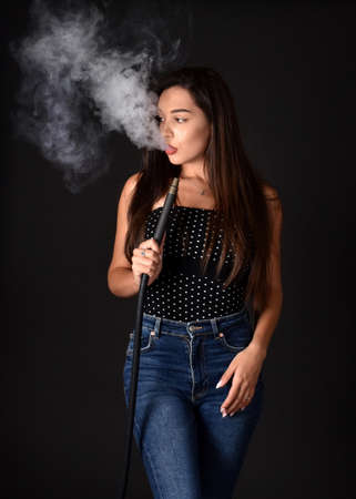 Beautiful and sexy girl smokes hookah, sheesha. Sexy woman smoking. The pleasure of smoking.の写真素材