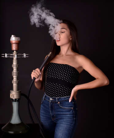 Beautiful and sexy girl smokes hookah, sheesha. Sexy woman smoking. The pleasure of smoking.の写真素材