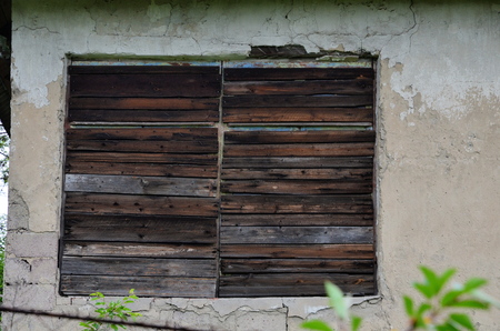 The window of an old abandoned house, boarded up.の写真素材