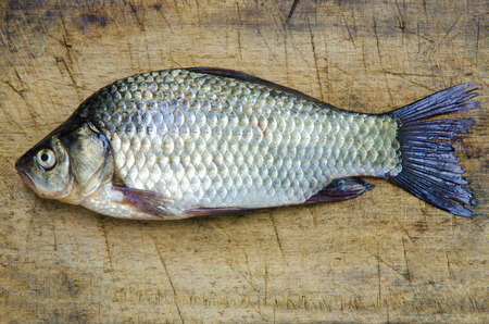 Carp lies on a board for cutting food.