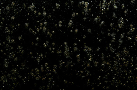 Texture of a black sheet of iron with rust and drops of water.