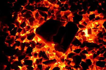 A decomposed large piece of coal on a burning shallow as a background.の写真素材