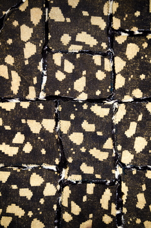 Texture of brown fabric with beige stains, sewn from pieces.