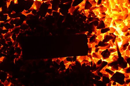 The background consists of flammable coal anthracite and a piece of metal.の写真素材