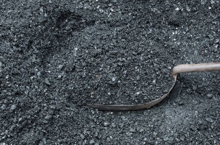 The metal scoop is filled with coal coal.の写真素材