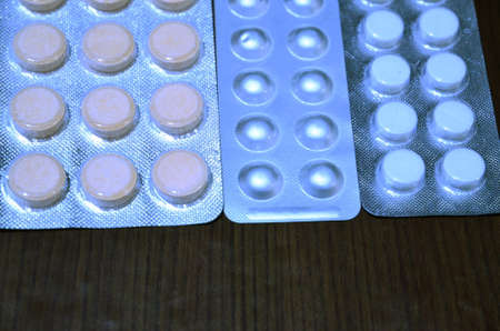 Three plates of different pills lie on the table.