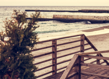 wooden ladder with railings on the beach during warm sunsetの写真素材