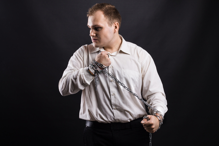 man in white shirt pulling  chain between handsの写真素材