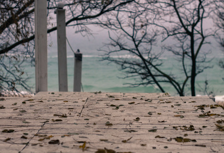 White wooden stairs down to beach. descent. Blue sparkling water. Costline of Black Sea,Odessa, Ukraine. Fallen autumn leaves are on stairs.の写真素材