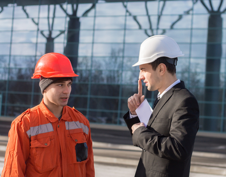 boss showing silence sign and giving a bribe or illegal inoficcial salary in an envelope. cash in hand. Business modern background.の写真素材
