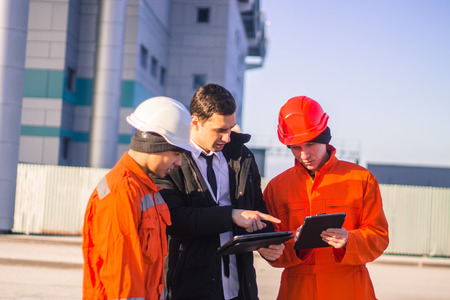 boss or Chief  instructs young team of  young engineers with a construction project on tablet. Technology in work.  Business modern backgroundの写真素材